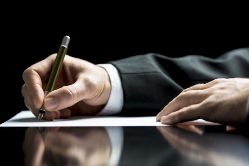professional man writing notes on paper for his business and resume writing letter