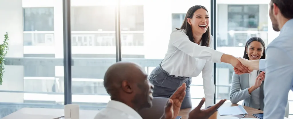 A hiring manager greeting a candidate during an interview while discussing what employers can legally disclose in reference checks.