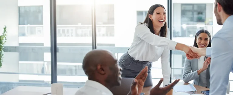 A hiring manager greeting a candidate during an interview while discussing what employers can legally disclose in reference checks.