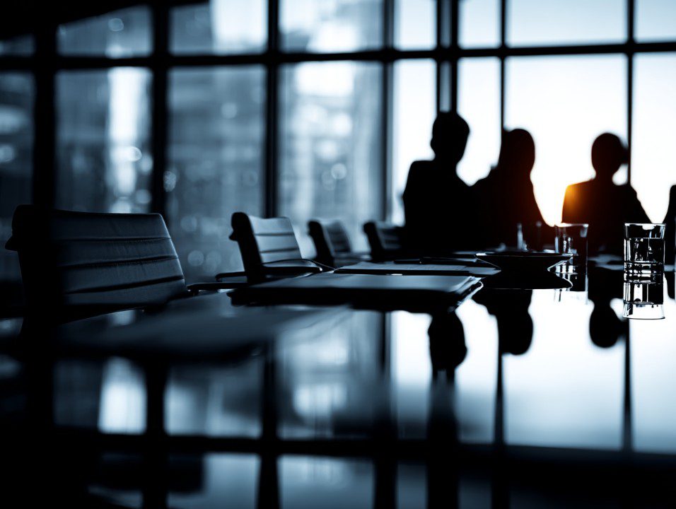 Silhouetted professionals in a conference room, representing communication gaps and candidate ghosting in modern hiring
