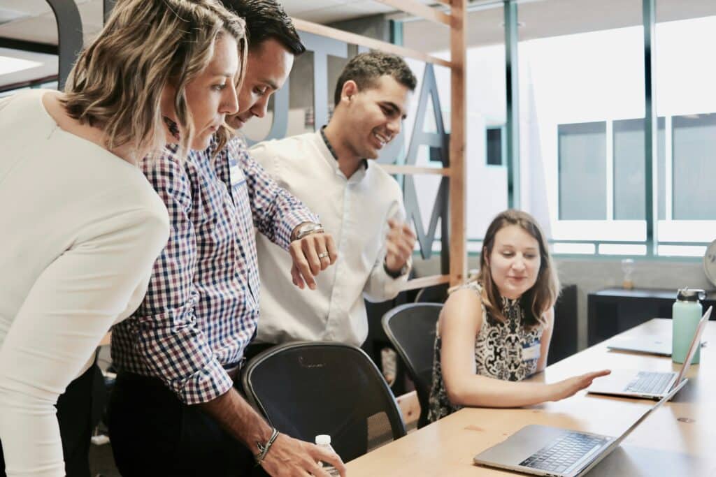 Office workers collaborating during a workday as hiring slows and job cuts increase