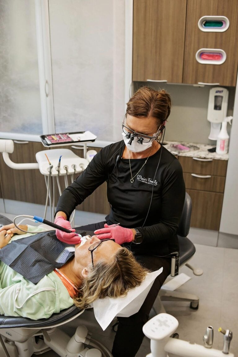 Dental hygienist providing patient care in a modern dental office as demand for Dental hygienist treating a patient as the dental hygienist shortage Kansas City practices face continues to increase demand for experienced RDHs.